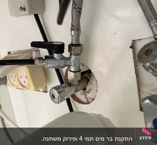 צנרת מתחת לכיור עם ברזים וצינורות